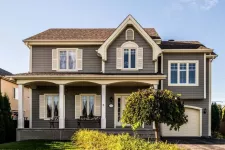 Maison traditionnelle avec un deuxième étage ajouté au-dessus du garage